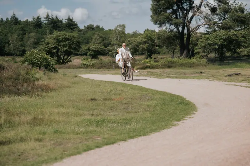 Bruid op de fiets over een zandpad op de Zuiderheide