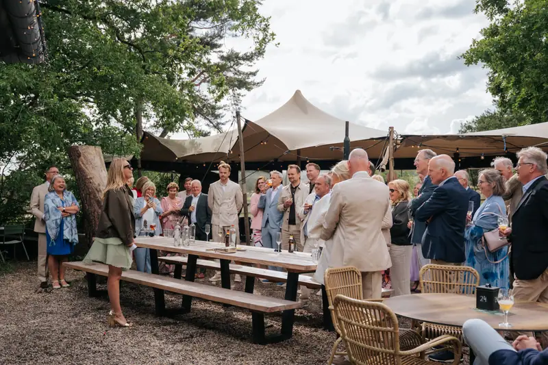 Gasten proosten tijdens de borrel onder de stretch tent