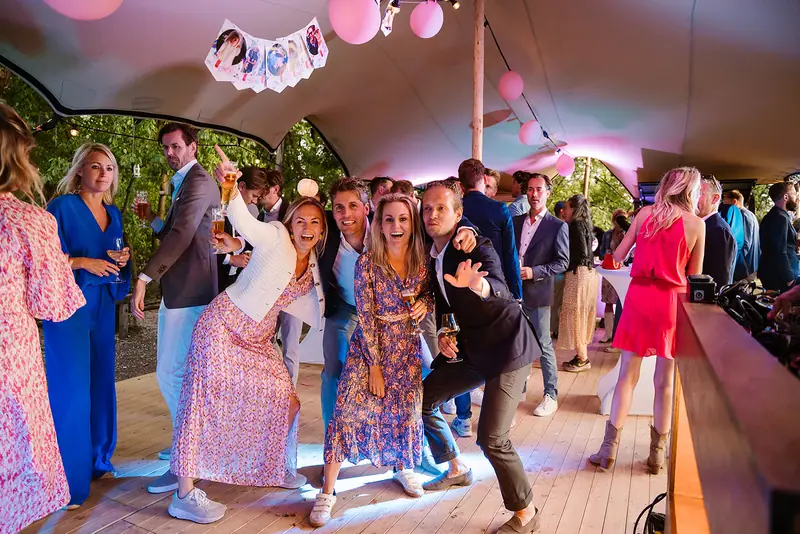 Gasten dansen onder de stretch tent met lichtjes